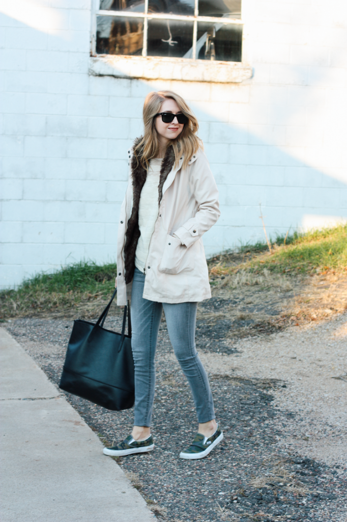 NTY Clothing Exchange mentioned in blogger pictured wearing large khaki winter coat with jeans and a large black tote and black sunglasses